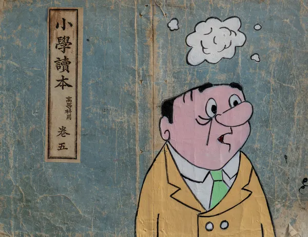 This piece features a pop-art style character painted atop a weathered vintage Japanese elementary school reader, creating a striking cross-cultural juxtaposition. The bold outlines and flat colors of the figure contrast with the aged, textured paper of the found object. The character's surprised expression and empty thought bubble suggest themes of cultural dialogue and individual introspection within a historical context.