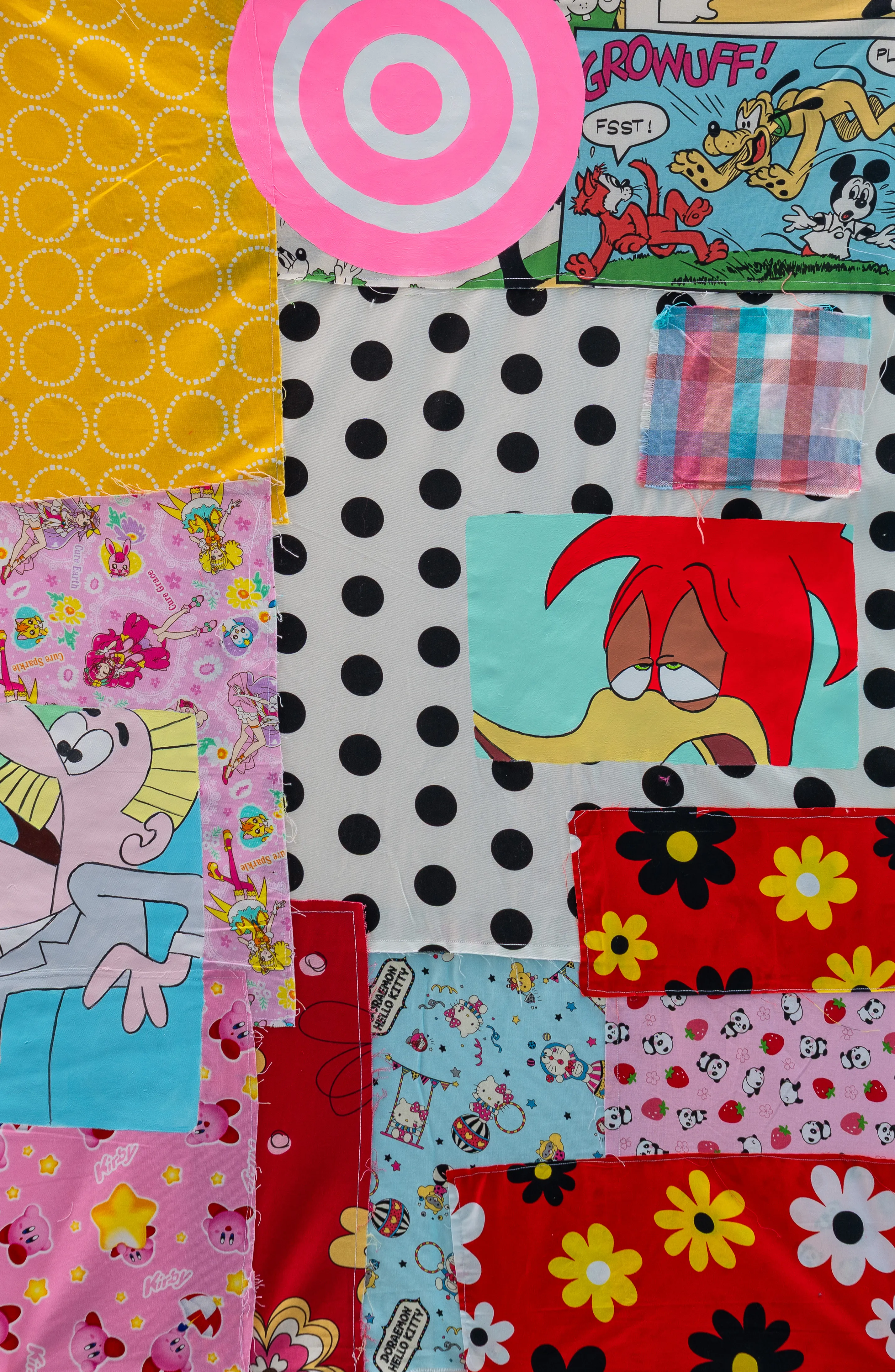 A vibrant textile assemblage that juxtaposes Western cartoon icons like Mickey Mouse and Woody Woodpecker with Japanese kawaii characters such as Kirby and Hello Kitty. The composition uses a collage-like patchwork technique, blending nostalgic pop culture imagery with bold patterns and hand-painted elements. The mood is playful and energetic, exploring the intersection of global media and consumerist aesthetics.
